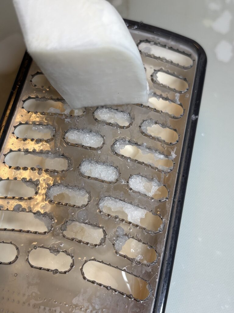 プラスチックのおろし金で大根をおろす