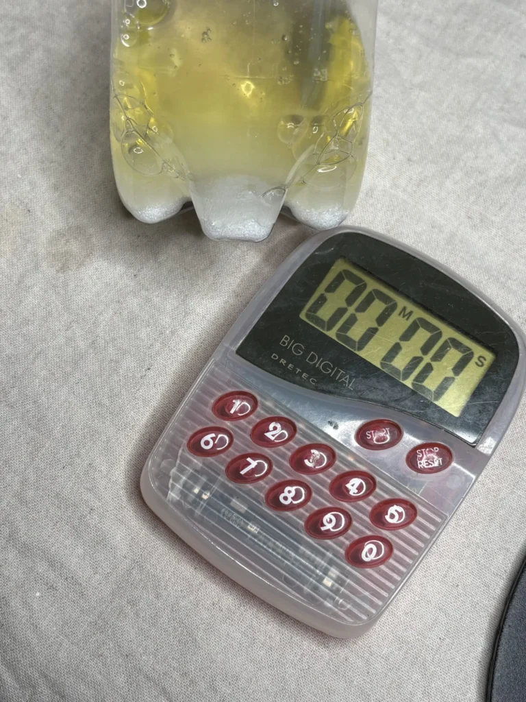 ペットボトルに入れた卵白と砂糖を振り始める